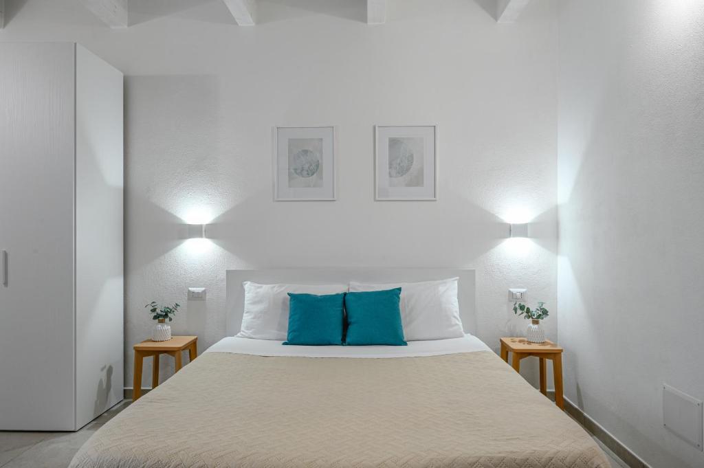 sypialnia z dużym łóżkiem z niebieskimi poduszkami w obiekcie DoMe Affittacamere w mieście Iglesias