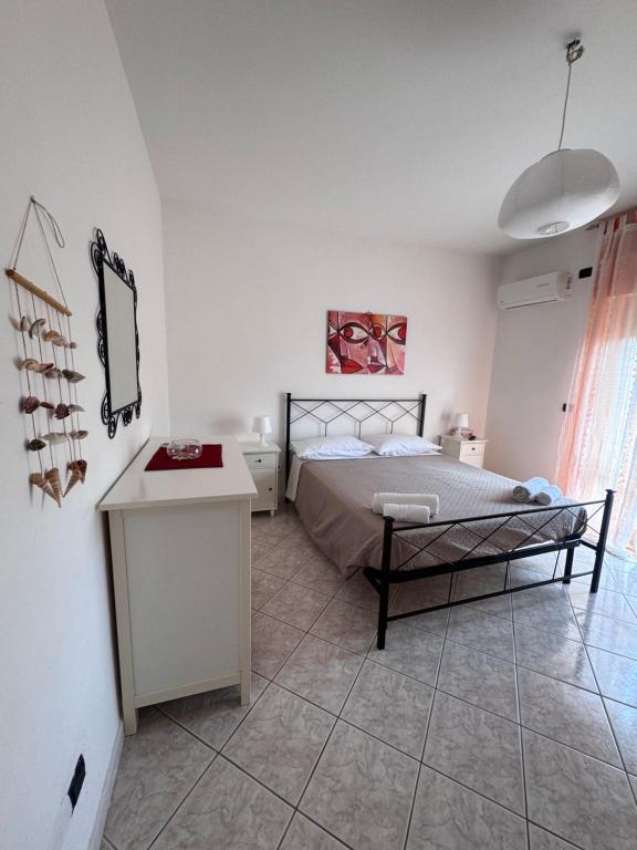 a bedroom with a bed and a tiled floor at Romagnosi apartment in Porto Torres