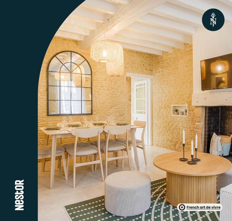 una sala da pranzo con tavolo, sedie e camino di Single House with Jacuzzi and Sauna in Normandy a Ranville
