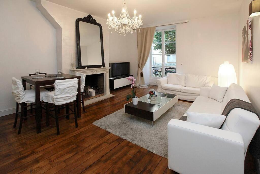 Una sala de estar con un sofá blanco y una mesa. en Royal Versailles Dolcevita St Louis, en Versalles