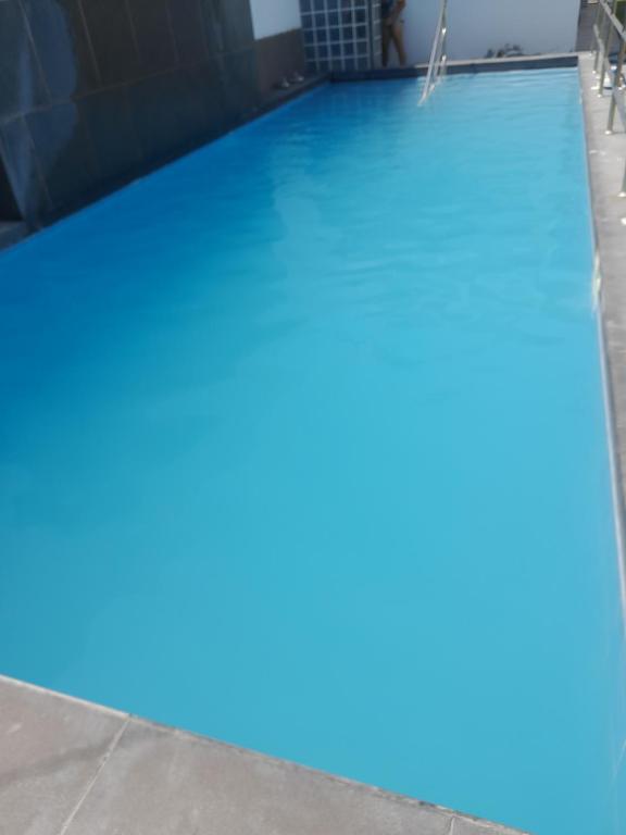 una piscina con agua azul en un edificio en Villa Valentino, en Trujillo