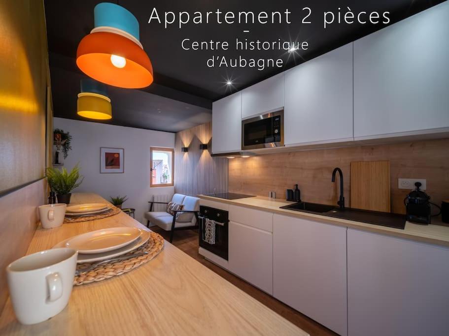una cocina con una mesa con platos. en Le Perchoir - Appartement 2 pers - Centre Historique, en Aubagne