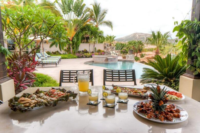 サン・ホセ・デル・カボにあるStunning Villa Cielos - Close to the Beachのテーブルに数皿の食べ物と飲み物を用意しています。