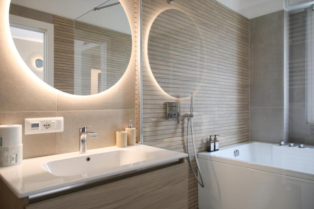 a bathroom with a sink and a large mirror at Casa Febo, in centro con parcheggio privato a 200 mt dal mare in Bordighera