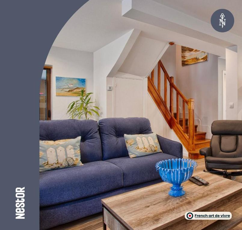 um sofá azul numa sala de estar com uma mesa em La Casa Bella - Calm and cosy house by the sea em Ouistreham