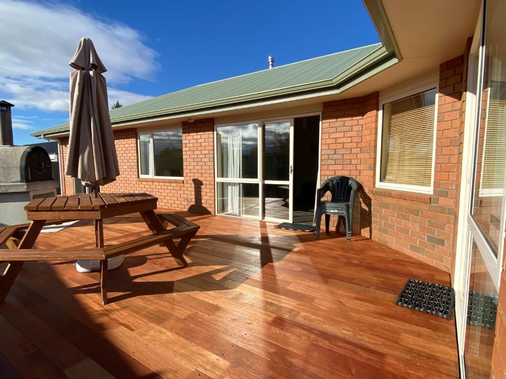 a patio with an umbrella and a wooden table at Views and Location in Twizel