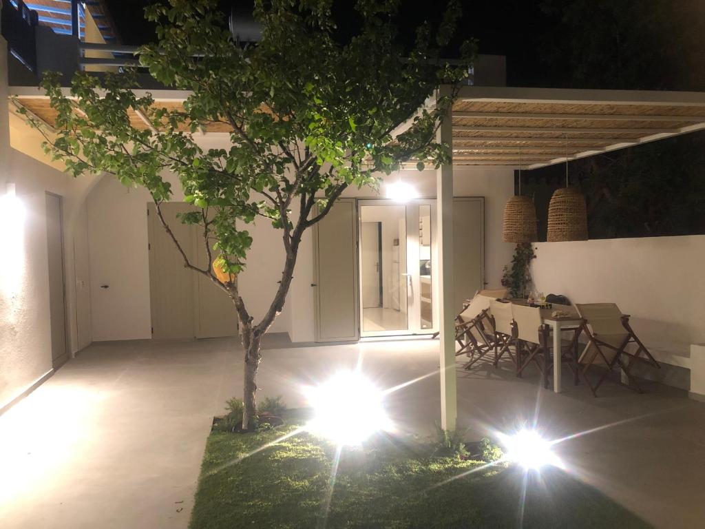 a room with a table and a tree and lights at Νissos K in Mérikhas