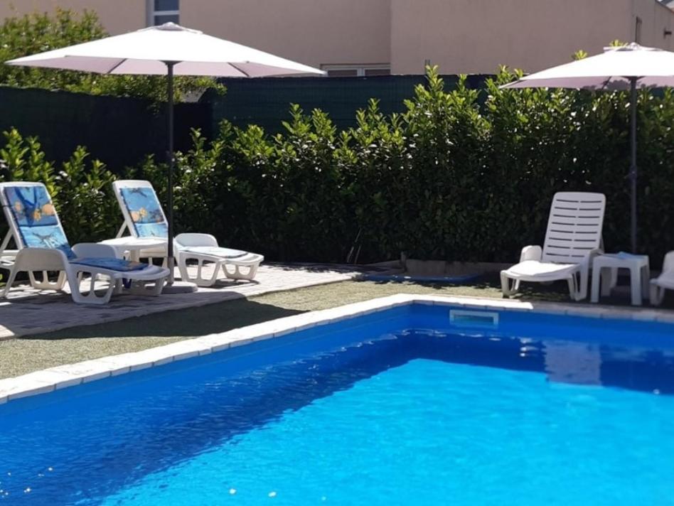 - un groupe de chaises longues et de parasols à côté de la piscine dans l'établissement Holiday Home Flora, à Mostar