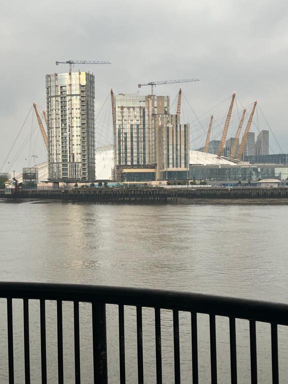 a view of a river with buildings and cranes at Canary Wharf O2 Arena Excel London in London