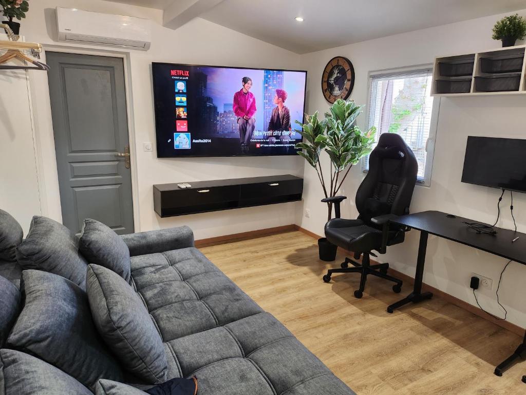 un salon avec un canapé et une télévision à écran plat dans l'établissement Gite à moins de 10 minutes de la cité médiévale de Carcassonne, à Carcassonne