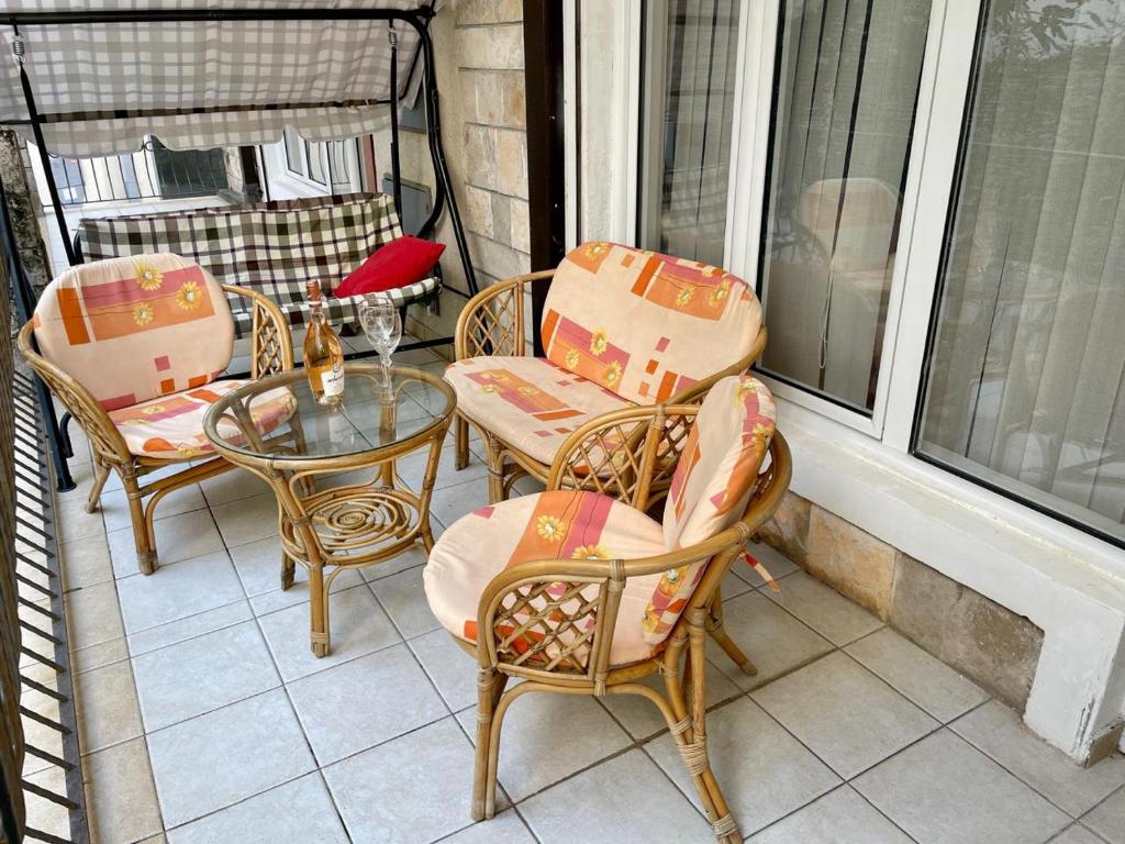 a patio with chairs and a glass table on a balcony at Boris Apartments in Petrovac na Moru