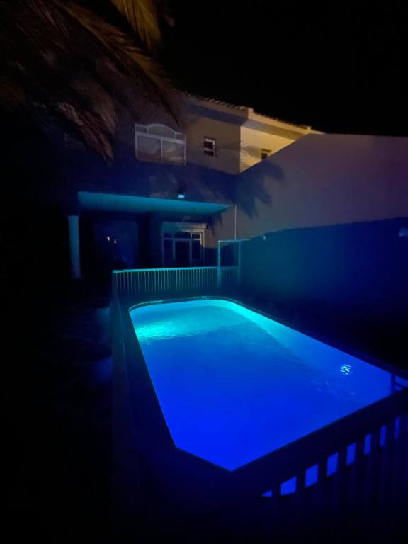ein blauer Pool in einem dunklen Zimmer in der Unterkunft درة العروس فيلا الذهبي 38 in Durrat Al-Arus