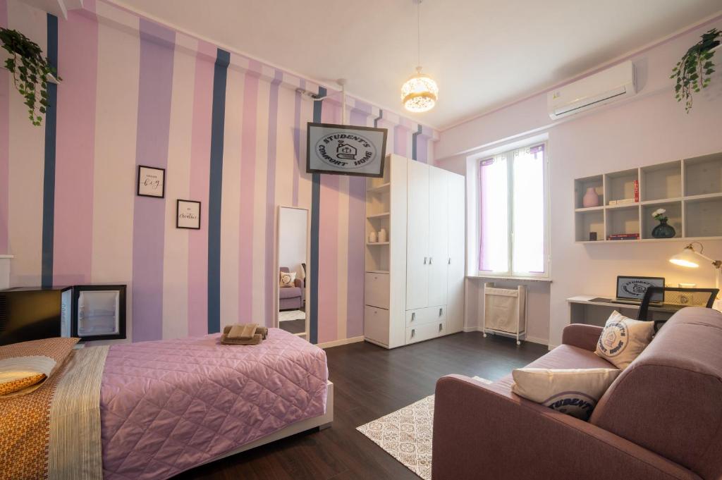 1 dormitorio con cama, sofá y reloj en Turin Comfort Home en Turín