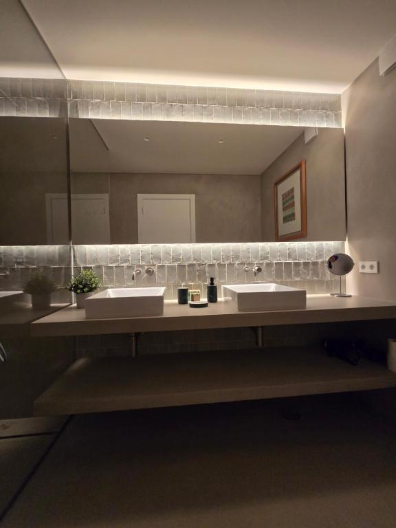 une salle de bains avec deux lavabos et un grand miroir dans l'établissement Vilamoura Dream House QR2, à Quarteira