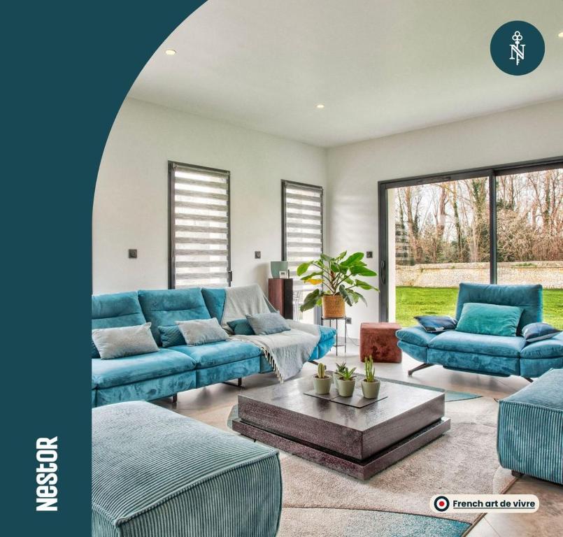- un salon avec des canapés bleus et une table dans l'établissement Villa Howard — Jacuzzi, Tranquility & Parking, à Ranville