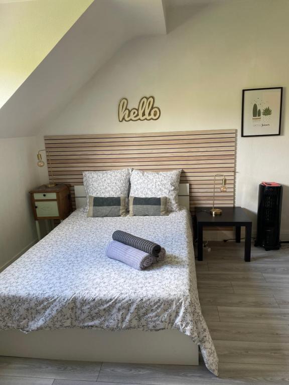 une chambre avec un lit blanc avec une tête de lit en bois dans l'établissement Studio tout confort dans Boulogne, à Boulogne-sur-Mer