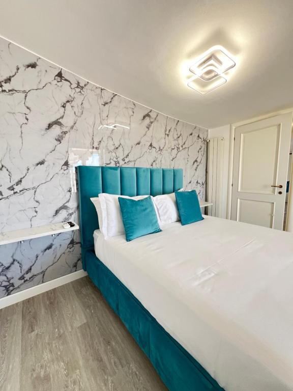 um quarto com uma cama grande e uma cabeceira azul em Mezzo Experience Holiday Home Eur em Roma