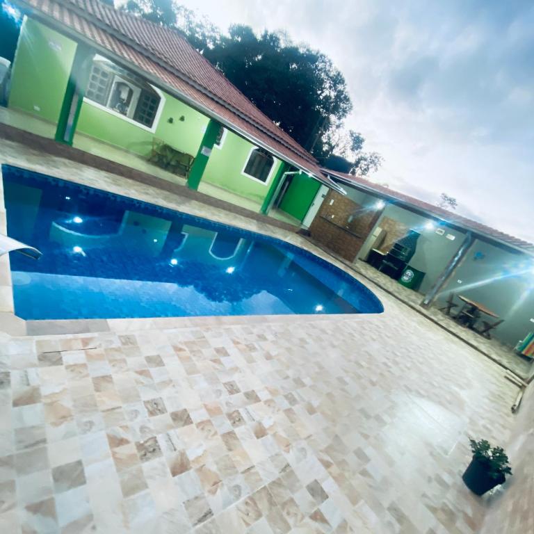 a swimming pool in front of a house at Chácara Li&Mazinho in Ibiúna