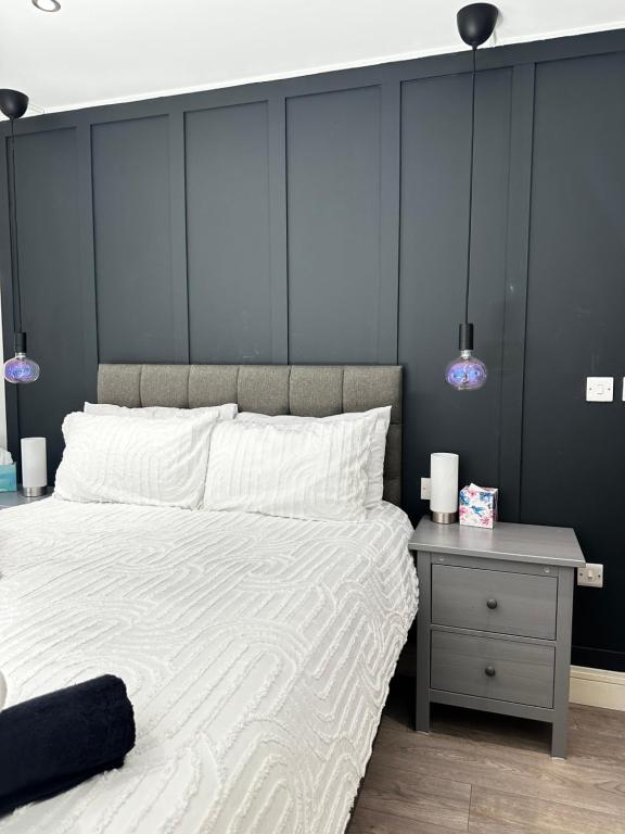 a bedroom with a large white bed and a night stand at Stylish Apartment City Centre in Sheffield