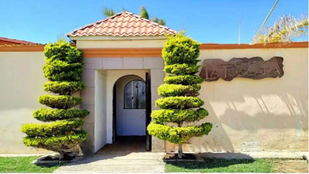 uma porta de uma casa com um arbusto em frente em Quinta La Toscana em Ensenada