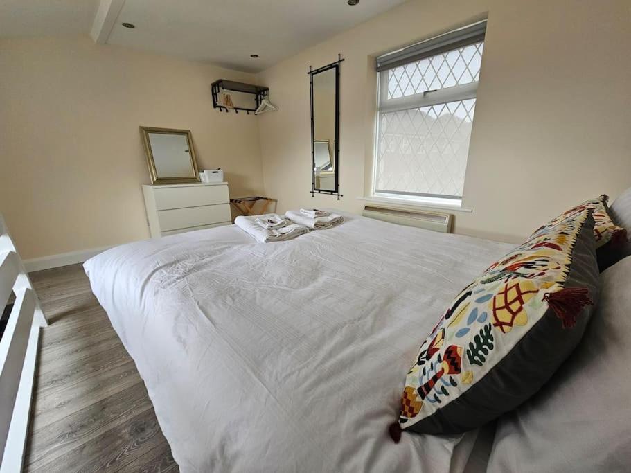 a bedroom with a white bed with a pillow on it at 1 Bed House Luton town center in Luton