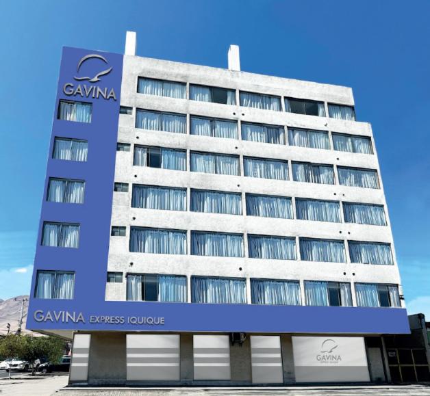 un grand bâtiment avec un panneau devant lui dans l'établissement HOTEL GAVINA EXPRESS IQUIQUE, à Iquique