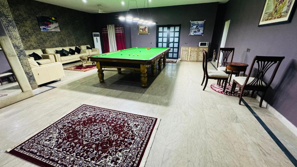 een woonkamer met een pooltafel en een tapijt bij Luxury Farmhouse for Stay and Events in Lahore