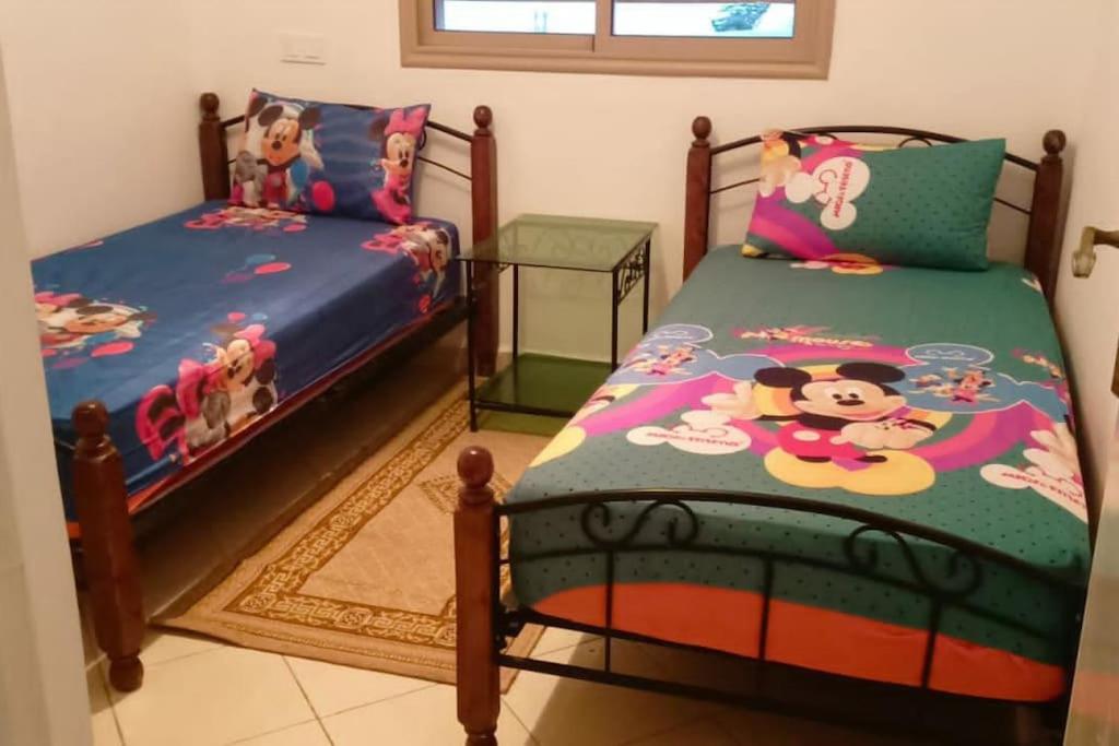 een slaapkamer met twee bedden met disney karakters erop bij appartement proche de la mer in Agadir