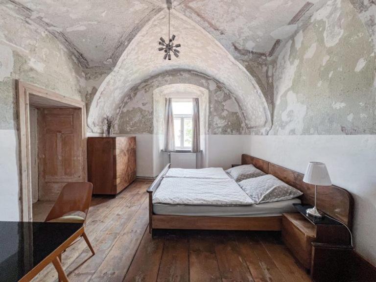 1 dormitorio con 1 cama en una habitación con techo en Ubytovanie v Kláštore - Hostel, en Rožňava