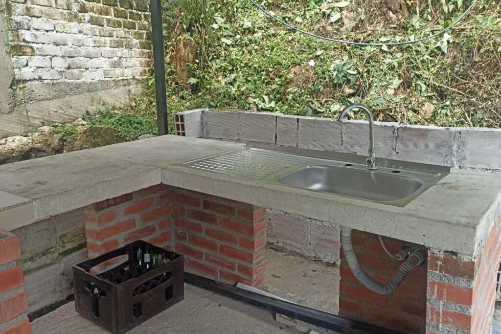 een betonnen aanrecht met een wastafel en een stenen muur bij Cabaña Mi Chelita in Ibagué