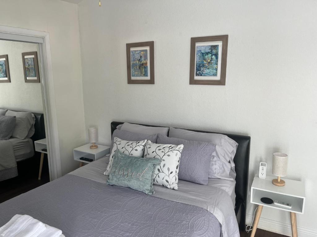 um quarto com uma cama e duas fotografias na parede em Habitación luminosa y acogedora. em Hollywood