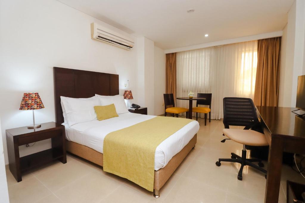 Postel nebo postele na pokoji v ubytování Hotel Millenium Barrancabermeja