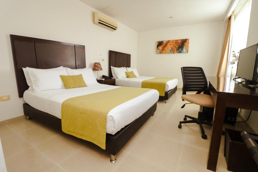 Postel nebo postele na pokoji v ubytování Hotel Millenium Barrancabermeja