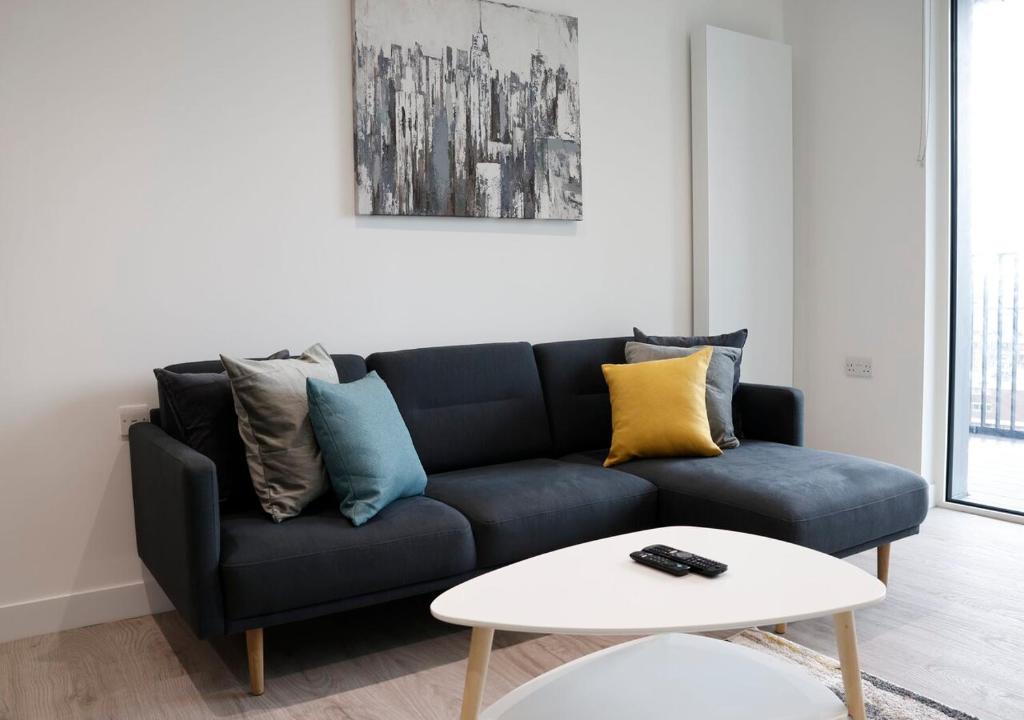克羅伊登的住宿－Modern New Spacious Apartment，客厅配有蓝色的沙发和白色的桌子