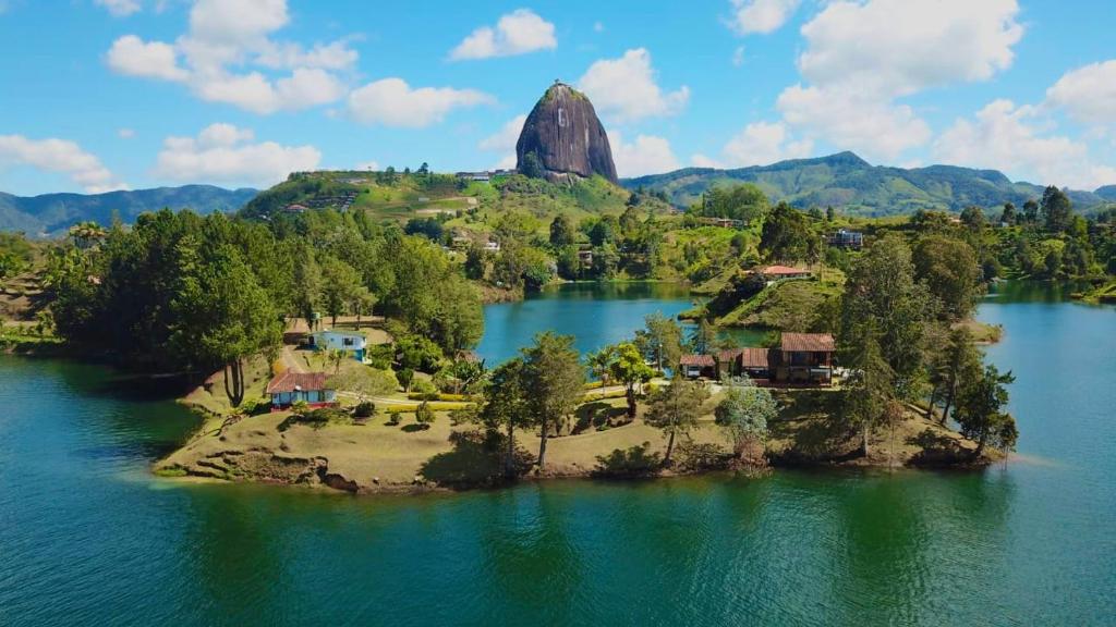 an island in a lake with a rock in the background at El Trebol in Guatapé