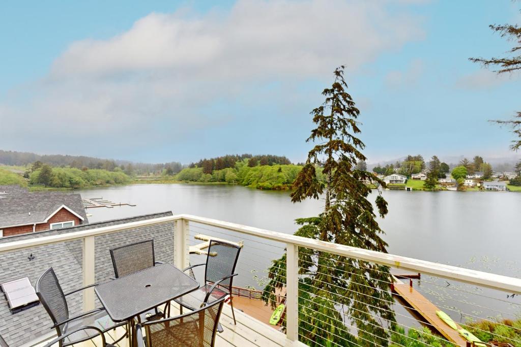 a balcony with a view of a lake at Lazy Lookout on Devils Lake in Lincoln City