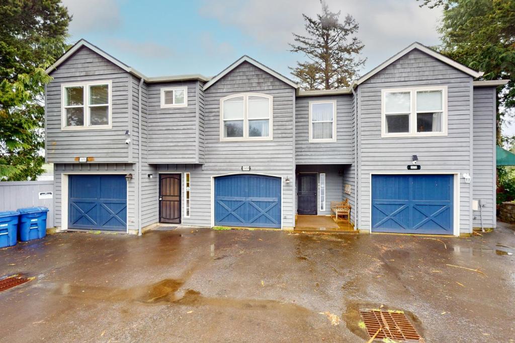 a house with blue garage doors in a parking lot at Lazy Lookout on Devils Lake in Lincoln City