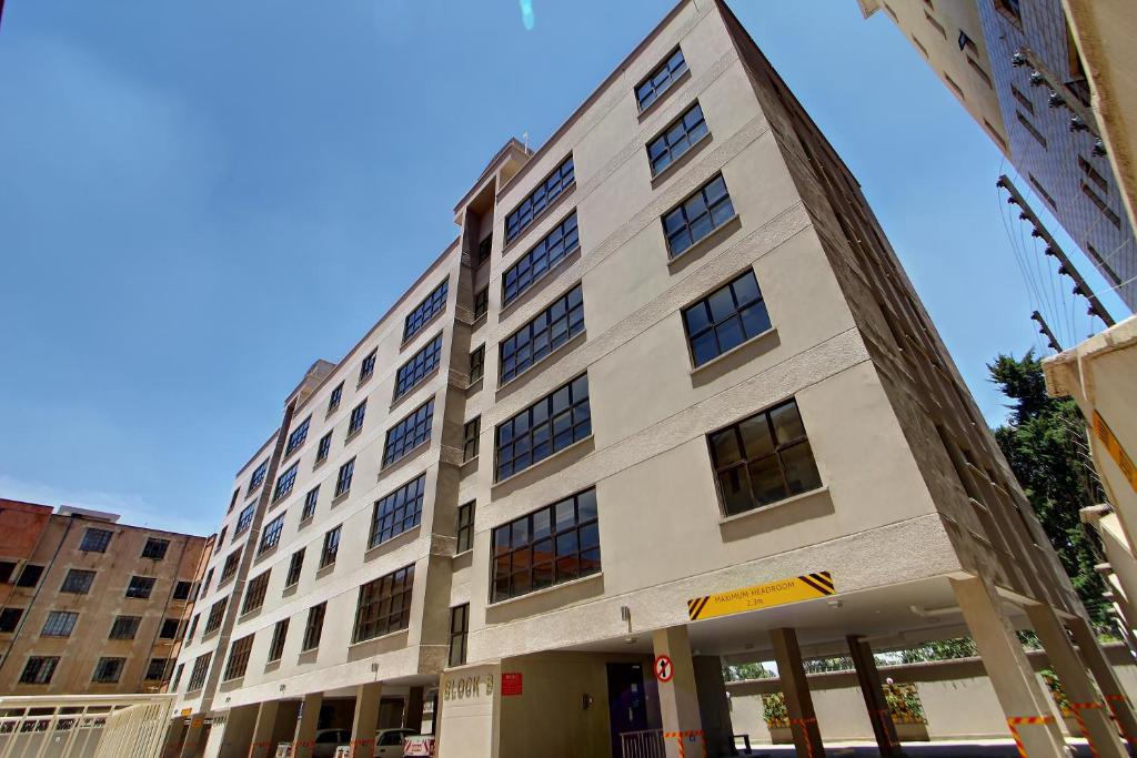 a large white building with windows on a street at Fedha Residences by Trianum in Nairobi