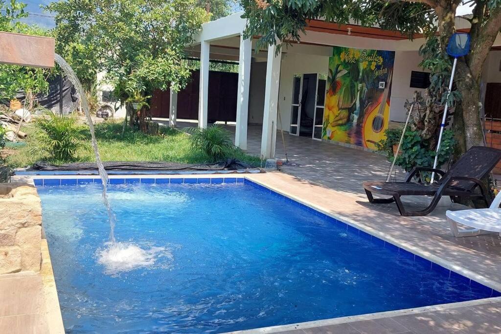 a swimming pool with a water fountain at Cabaña Ana Emilia, lugar mágico in Ginebra