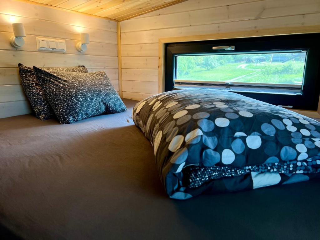 Schlafzimmer mit einem Bett mit einem Kissen und einem Fenster in der Unterkunft Tiny Home in Dejani