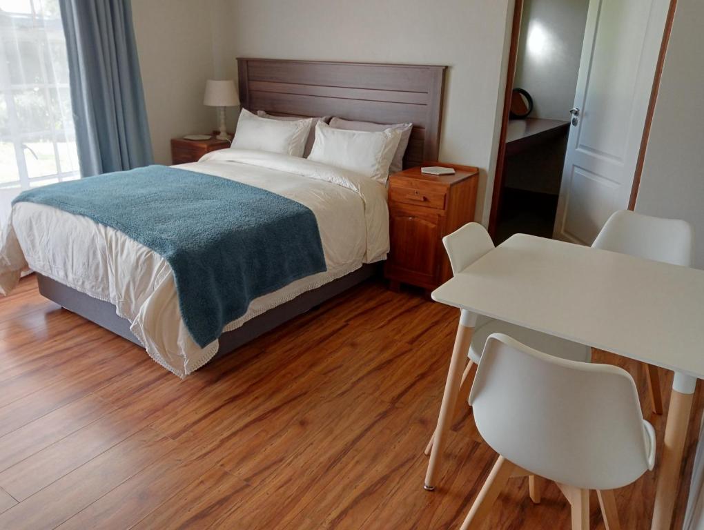 a bedroom with a bed and a table and chairs at Wapadrand Guest Suite in Pretoria