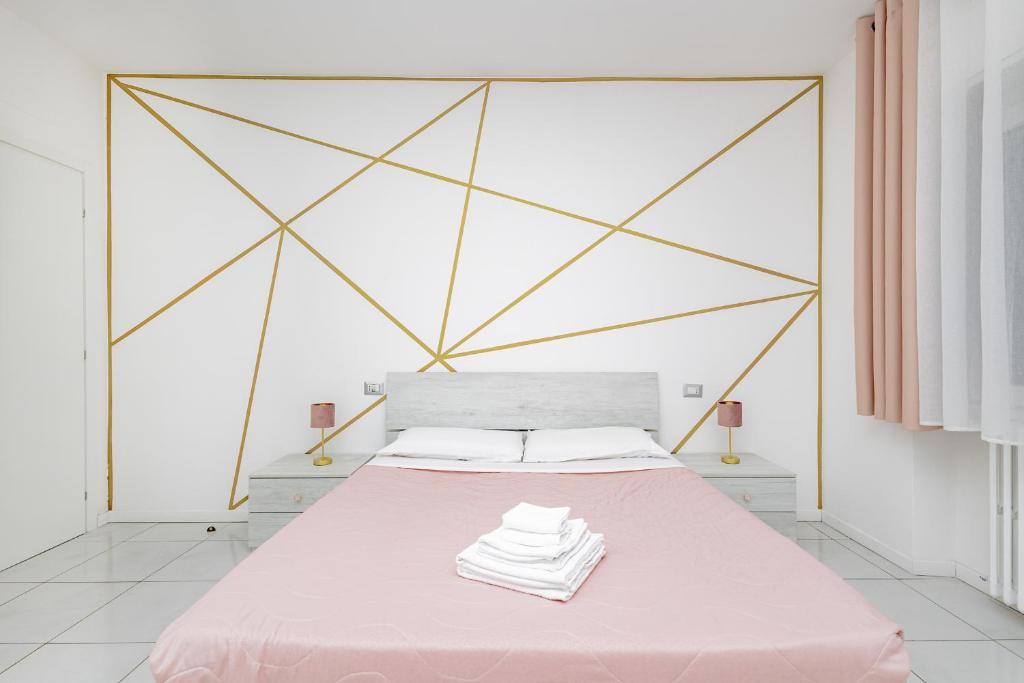 a bedroom with a pink bed with a geometric headboard at Holidays in Lecco