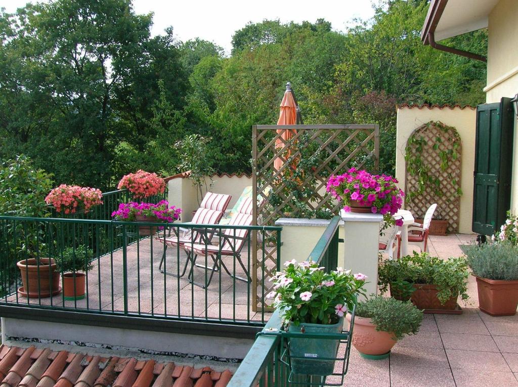 ArcugnanoにあるB&B Il Suono del Boscoの鉢植えの植物と花が飾られたバルコニー