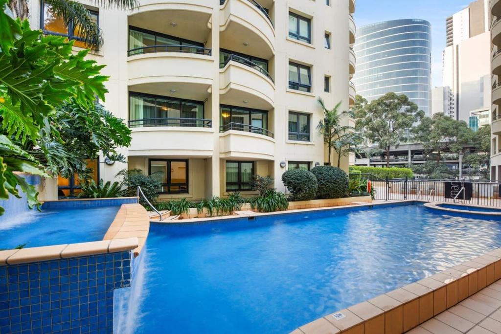 a swimming pool in front of a building at Contemporary 1-Bed First Floor Unit with Pool in Sydney