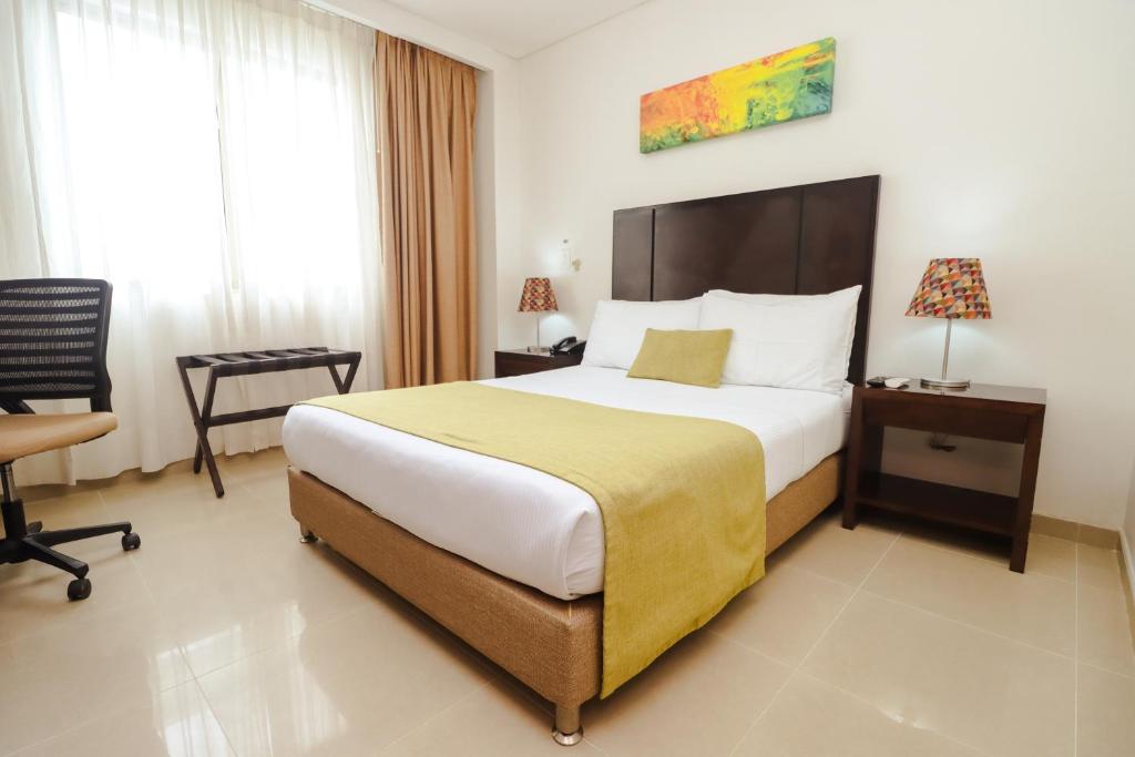 Postel nebo postele na pokoji v ubytování Hotel Millenium Barrancabermeja