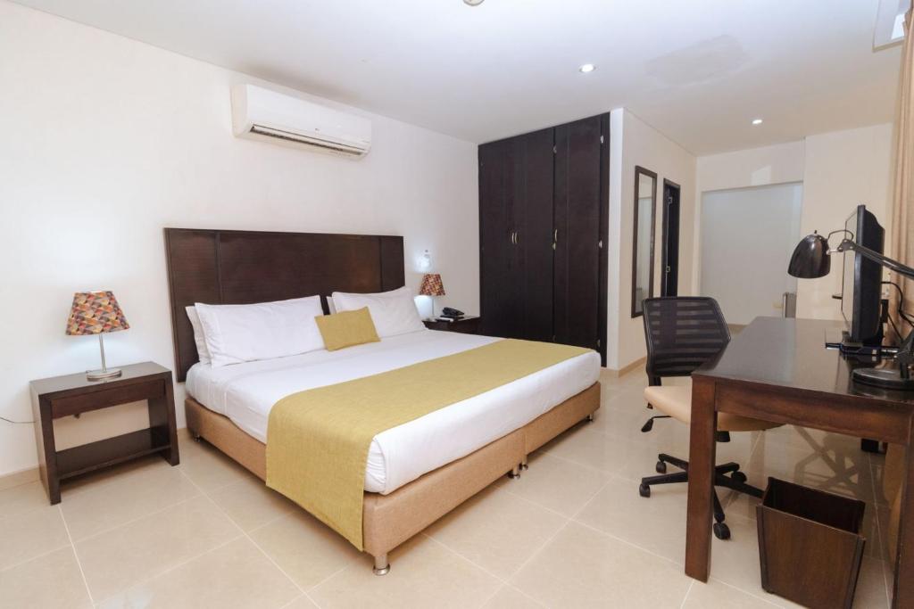 Postel nebo postele na pokoji v ubytování Hotel Millenium Barrancabermeja