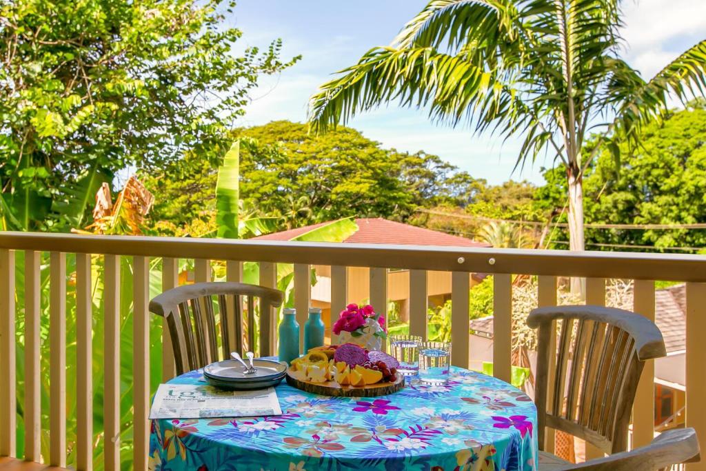 une table avec une assiette de nourriture sur un balcon dans l'établissement Waikomo Stream Villas 332, à Koloa