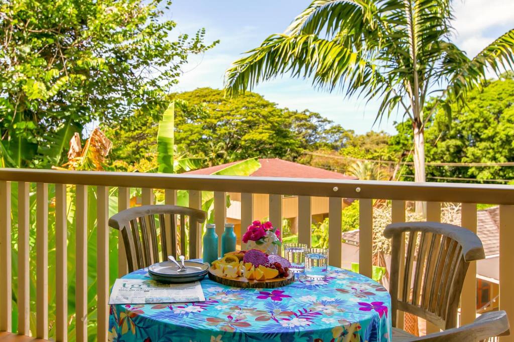 a table with a plate of food on a balcony at Waikomo Stream Villas 332 in Koloa