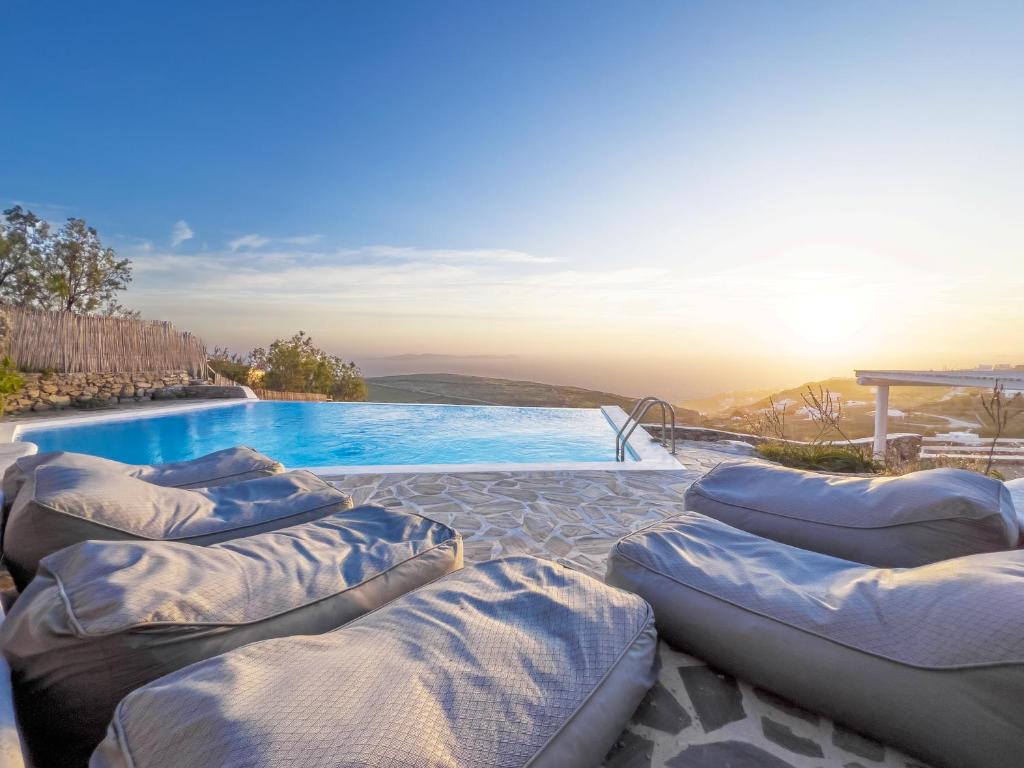 a group of pillows sitting next to a swimming pool at Villa Prive 88 Mykonos in Fanari