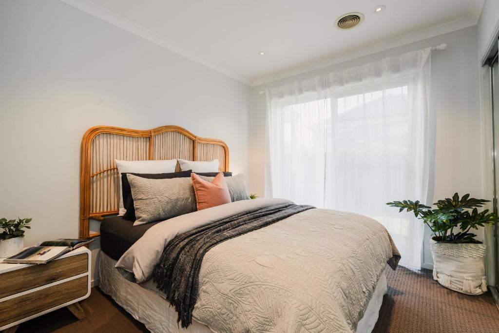 a bedroom with a large bed and a window at Hamptons Haven Luxe 4 bedroom, 2 bathroom, WIFI, Great for wedding stays Managed by Host On The Coast in Mount Duneed